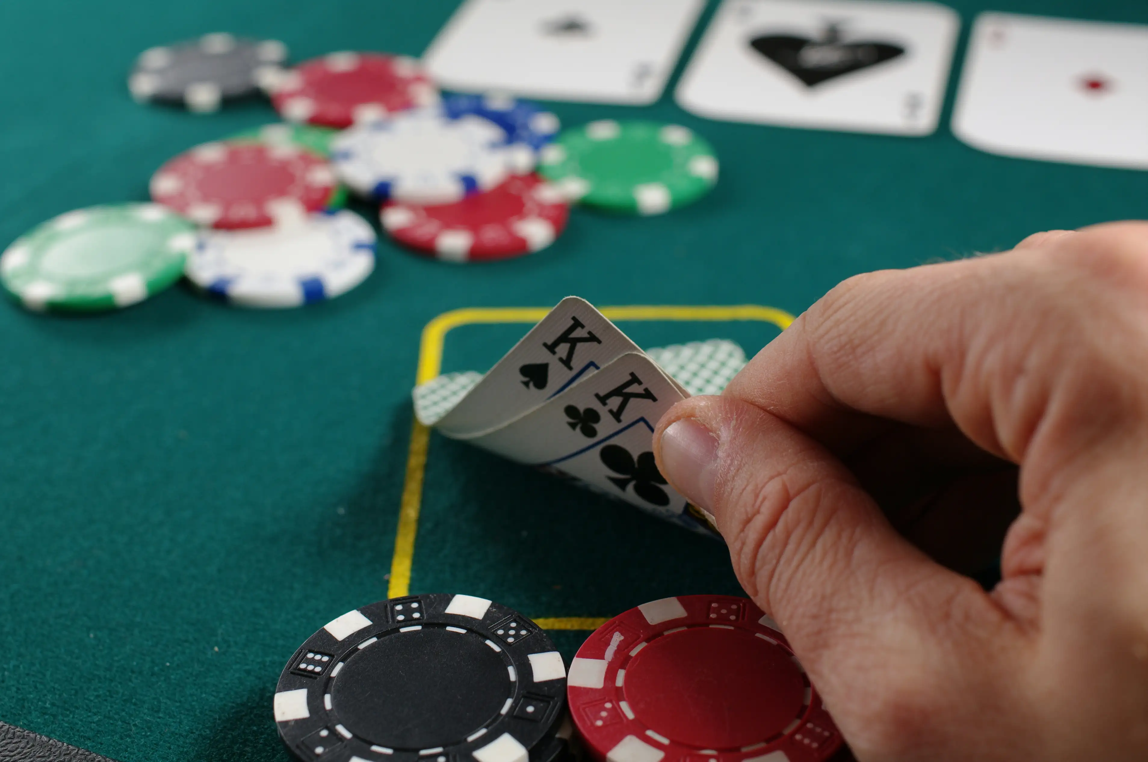 Spiller som holder kort ved et pokerbord